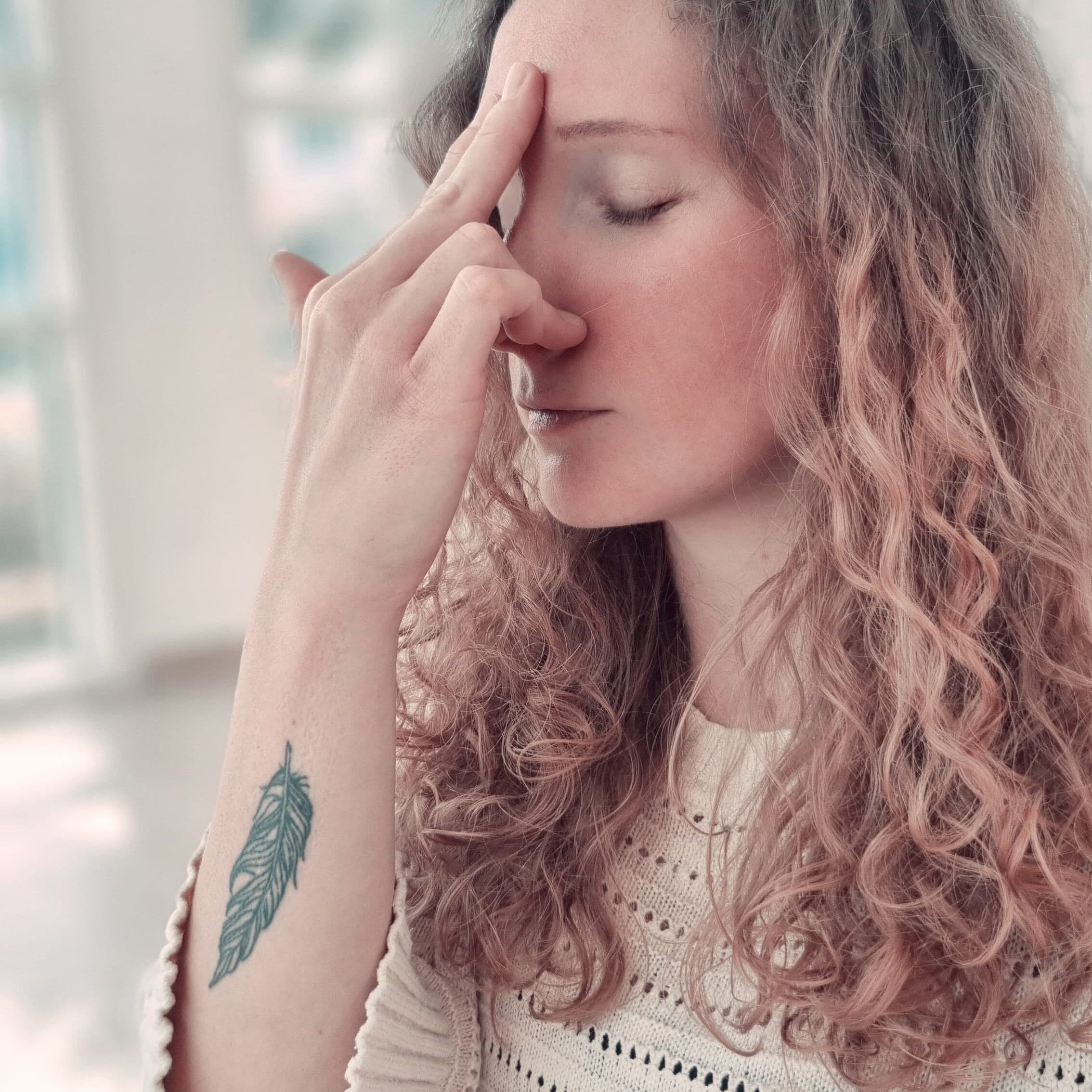 Alina Saibel seated in a cross-legged position, eyes closed, practicing Pranayama (yogic breathwork) during an outdoor yoga session – hands gently resting on knees, face calm and serene, embodying focus and inner peace